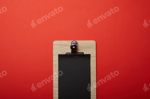 Preview: elevated view of blank black menu on red surface, minimalistic concept