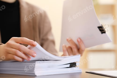 Preview: Woman working with documents at table in office, closeup