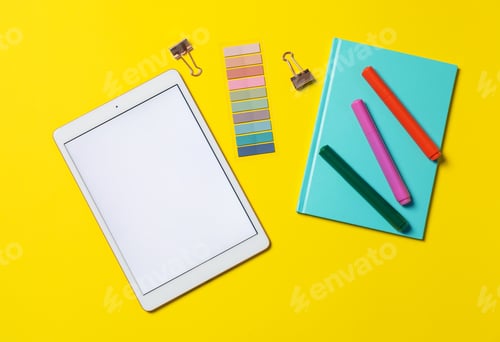Preview: Tablet and different stationery on yellow background, flat lay