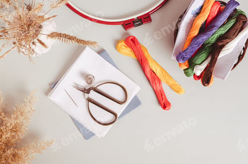 Preview: Canvas, embroidery floss, scissors, needle, thimble and cross stitch hoop on table top view