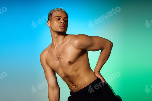 Preview: Young shirtless African American man with dyed hair showcasing confidence in the studio
