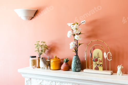 Preview: Cute cozy chic home fireplace mantle with terracotta colored walls and flowers, vases and jewelry