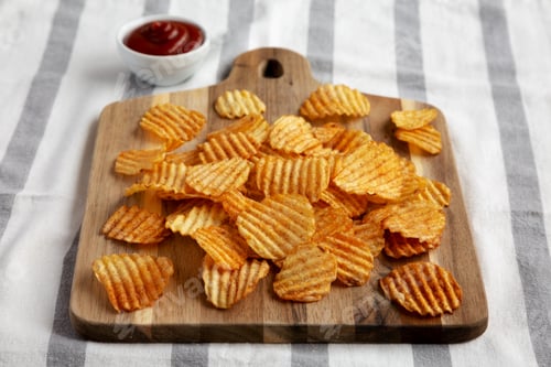 Preview: Barbeque Potato Chips on a wooden board, low angle view.