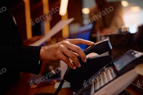 Preview: Close up of receptionist answering a phone call while working in a hotel.