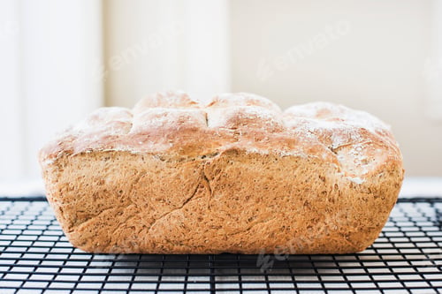 Preview: Freshly baked loaf of whole wheat bread on cooling rack