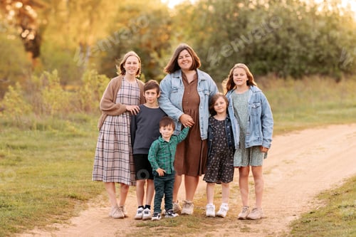 Preview: A large friendly family walks in a field in the summer