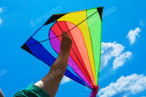 Preview: Woman with colorful kite under blue sky, low angle view