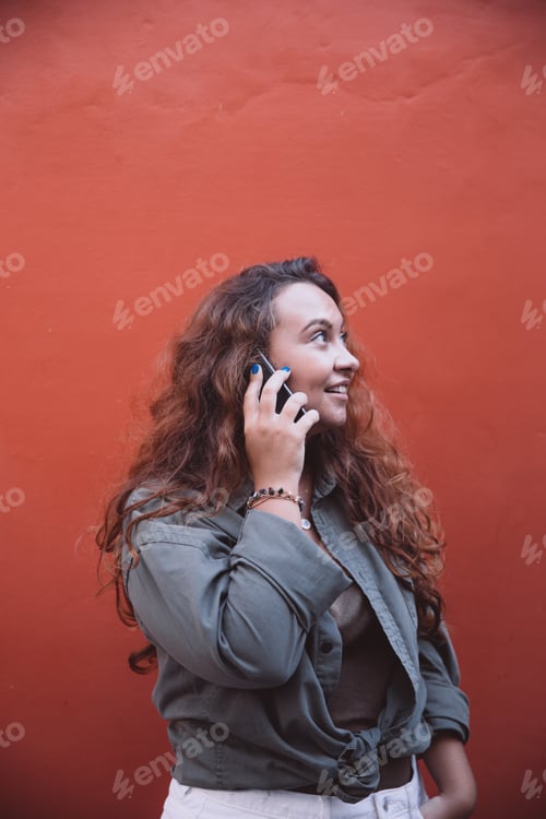 Preview: Beautiful plus size woman with curly hair talking by phone