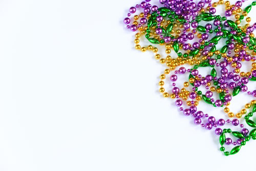 Preview: Mardi Gras background. Gold, green and purple beads on white background. Fat Tuesday symbol.