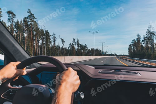Preview: Man driving modern car on the highway road in autumn season.