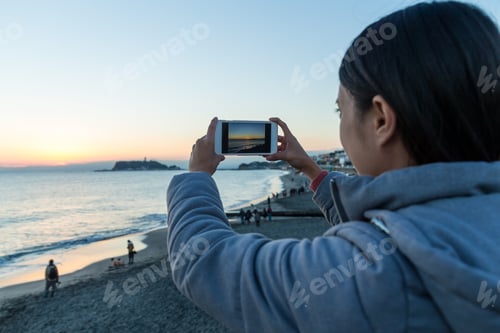 Preview: Woman taking photo for the sunset