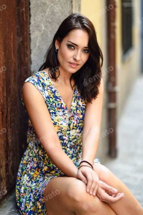 Preview: Beautiful young woman with blue eyes sitting on urban step.