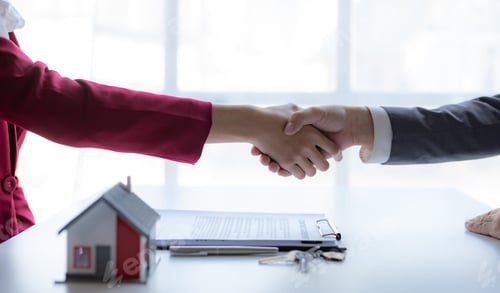Preview: Real estate agent shaking hands with a client to sign a home purchase contract and congratulate