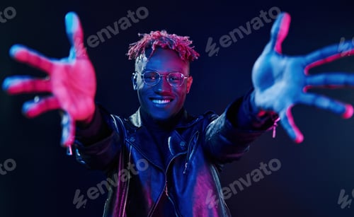Preview: Having fun. Futuristic neon lighting. Young african american man in the studio