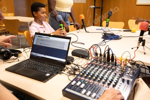 Preview: African young boy learning podcast recording using microphones and mixer
