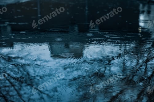 Preview: Rain drops falling down onto puddle outdoors