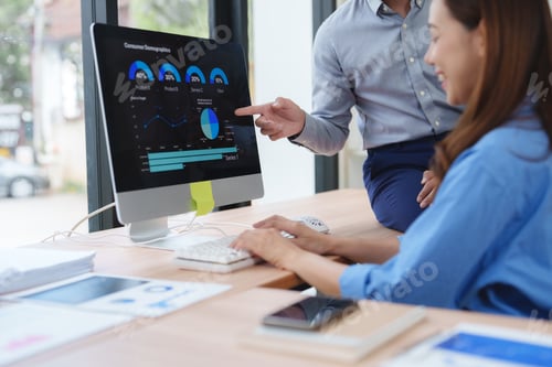 Preview: Business people analyzing financial charts and graphs on computer screen in office meeting