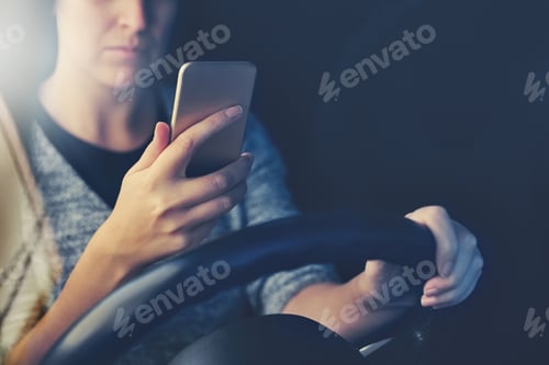 Preview: Stay alive - dont text and drive. Shot of a woman using a phone while driving.