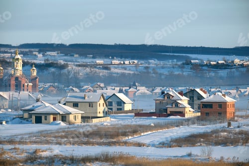 Preview: Aerial view of private homes with snow covered roofs in rural suburbs town area in cold winter