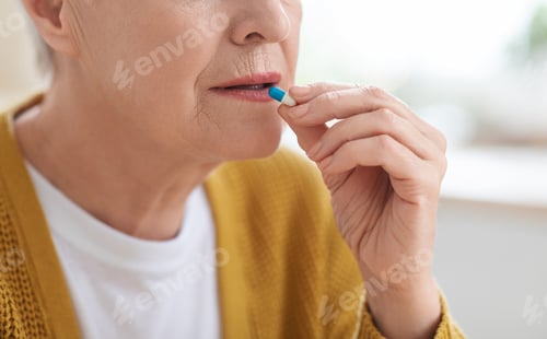 Preview: Cropped of senior woman with glass taking medicine