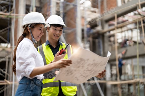 Preview: engineering and construction managers discussing project blue print on the table at construction