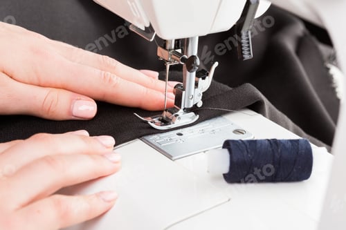 Preview: Sewing fabric with a sewing machine using a dark thread and close attention to detail