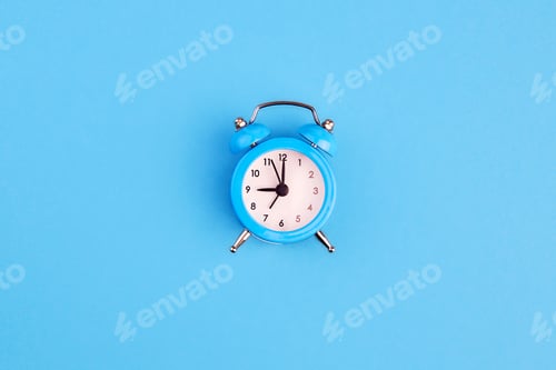 Preview: Classic alarm clock on blue background. Top view, copy space.