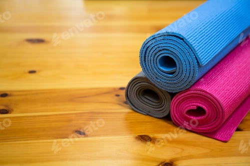 Preview: Rolled Yoga Mats Stacked on Light Wood Floor