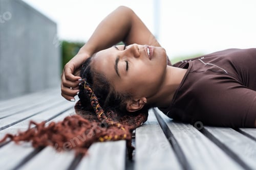 Preview: Portrait of young woman lying on a bench.