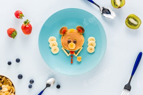 Preview: flat lay with creatively styled children's breakfast with berries and kiwi