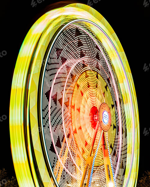 Preview: Vertical shot of long exposure of the colorful ferris wheel at night in the amusement park