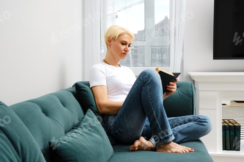Preview: Woman Relaxing on Sofa Reading a Book
