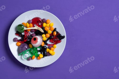 Preview: Assortment of Halloween candies isolated on purple background