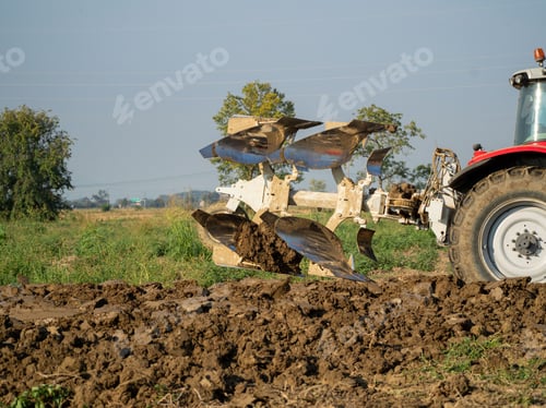 Preview: Farmer driving tractor plowing land at the end of the summer season