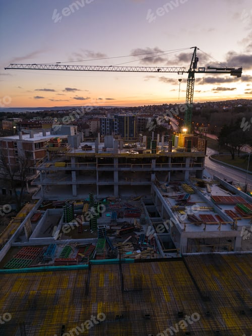 Preview: Busy Construction Site and Construction Equipment at night. Aerial view