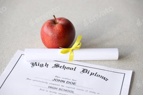 Preview: A high school diploma lies on table with small scroll and red apple. Education documents