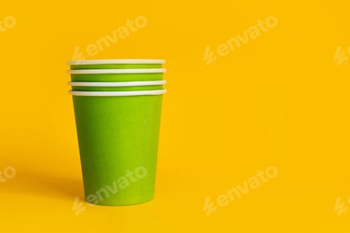 Preview: Green paper cups with striped paper straw on yellow background