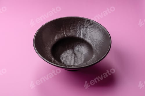 Preview: An empty round ceramic plate on a pink background as a kitchen utensil. An empty plate