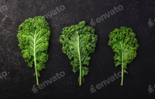 Preview: Kale cabbage. Green vegetable leaves, top view on black background