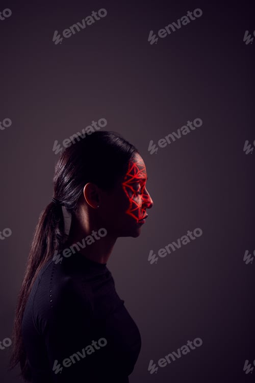 Preview: Facial Recognition Technology Concept As Woman Has Red Grid Projected Onto Face In Studio