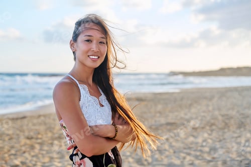 Preview: Outdoor portrait of young beautiful asian woman on beach, looking at camera