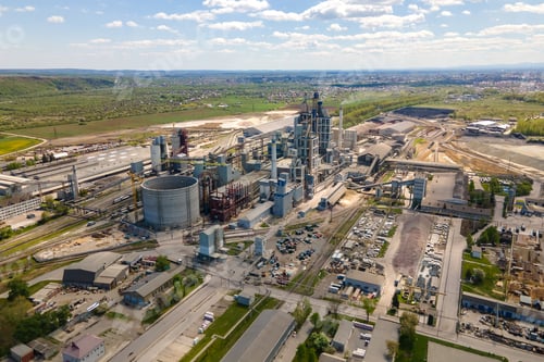 Preview: Aerial view of cement plant with high concrete factory structure and tower crane