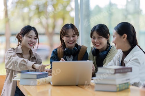 Preview: Group of young Asian college students sitting on a bench in a campus relaxation area, talking