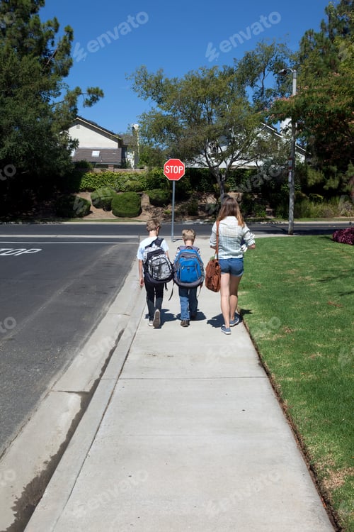 Preview: Teenage girl walking brothers to school along sidewalk