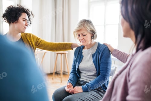 Preview: Men and women sitting in a circle during group therapy, supporting each other.