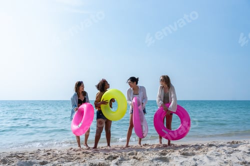 Preview: Group of diverse young women smiling on a sunny beach. Youth Friends Enjoying Sea Splash Together.