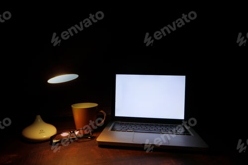 Preview: laptop with blank screen with table lamp on desk