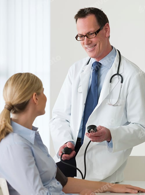 Preview: Doctor checking patient's blood pressure with a smile.