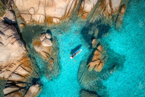 Preview: Aerial view of couple on sup board, blue sea, rocks in summer