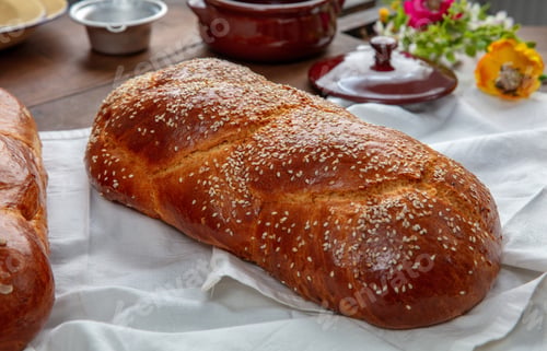 Preview: Easter sweet bread, two tsoureki braids on white table cloth, closeup